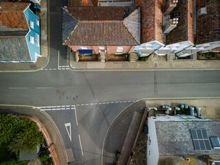 Drone top down view of a major road junction is the English seaside town of Aldeburgh, Suffolk. Showing the standard Give Way road markings. A narrow street leading to the seafront can be seen.