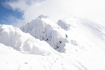 A person going down the mountain in winter with skis. Snow covered mountains in winter.