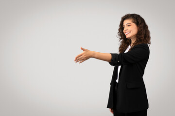 Businesswoman reaching out for handshake, free space