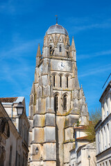 Saintes, Charente-Maritime, France in spring. View of old city street and Cathedral Saint-Pierre at background. European architecture and heritage.