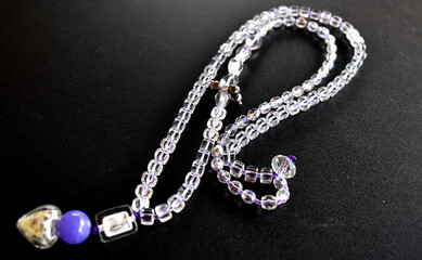 transparent necklace on a black surface