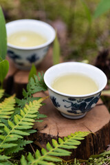 Fototapeta na wymiar Two cups of green tea on wooden stands