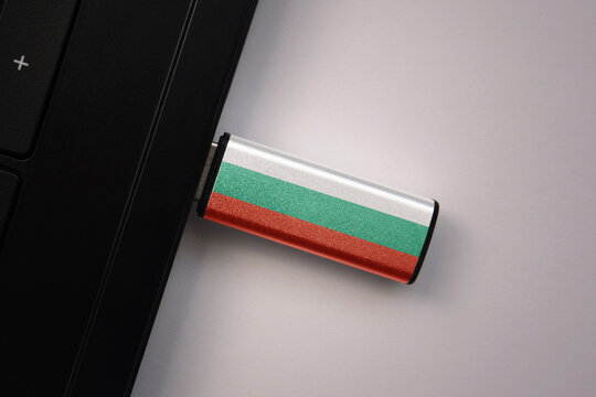 usb flash drive in notebook computer with the national flag of bulgaria on gray background.
