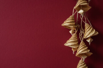 Bells made out of straw on a red background. Straw bells decorations. Straw weaving. Place for text