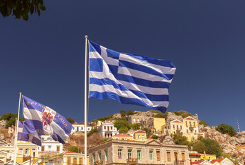 Greek national flag against a background of blue sky and mountains. - 755859645
