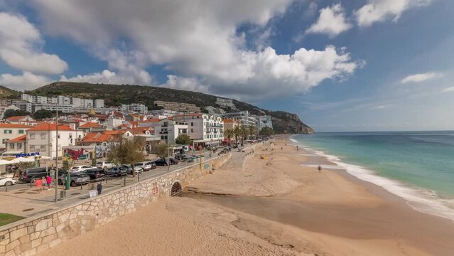 Panorama showing aerial view of Sesimbra Town and seaside walking waterfront timelapse, Portugal. Top landscape with houses and beach from fortress. Resort in Setubal district