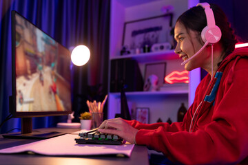 Host channel of young beautiful Asian gaming streamer, playing battle team gaming with multiplayer or single at warship on screen, wearing pastel color headset at digital neon light room. Stratagem. - obrazy, fototapety, plakaty