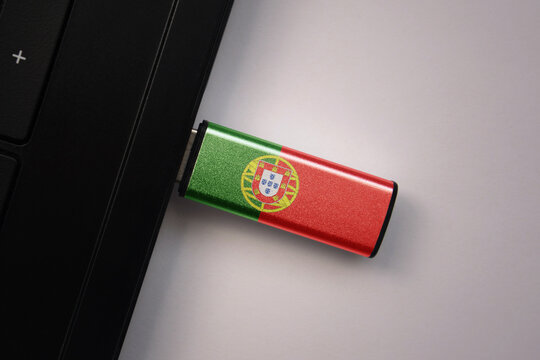 usb flash drive in notebook computer with the national flag of portugal on gray background.