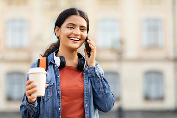 Portrait of smiling young eastern woman talking on phone