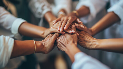 Obraz premium Close-up view of a group of diverse hands placed one on top of the other in a stack