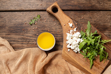 Close-up of rucolla, cottage cheese on a wooden board. Healthy vegetarian breakfast. Top view