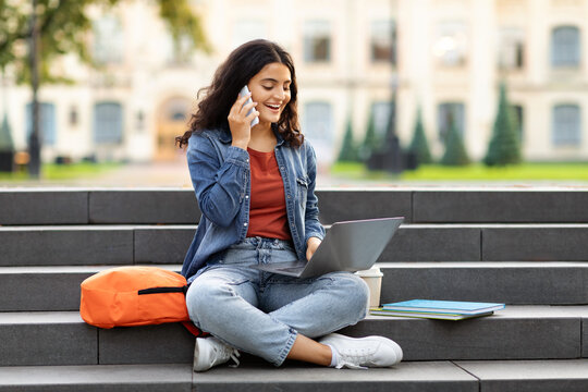 Young eastern woman student doing homework, calling her classmate