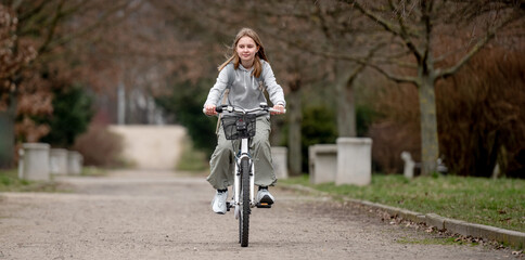 Warm Weather Sees Girl Riding Bicycle Through Spring Park - 755875491