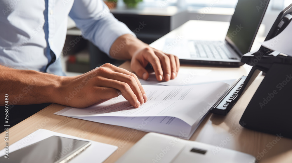 Poster close-up of a man working with a stack of documents and reports on his office desk