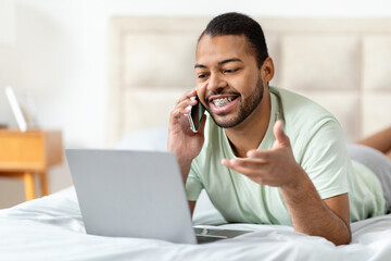 Black businessman working from home, have phone conversation, bedroom interior