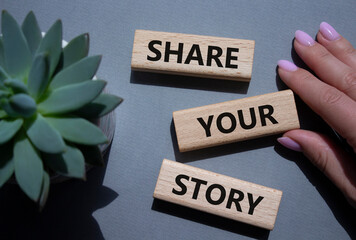 Share your story symbol. Wooden blocks with words Share your story. Beautiful grey background....