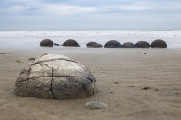 stones on moeraki boulders beach on cloudy day in new zealand