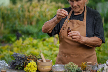 An elderly woman holds a herbal extract in her hands. Selective focus.