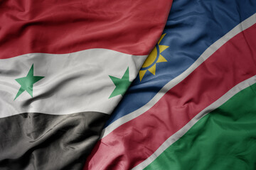 big waving national colorful flag of namibia and national flag of syria .