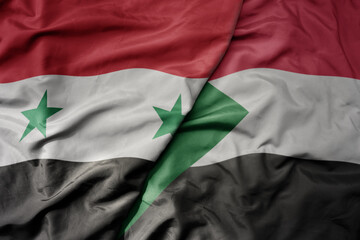 big waving national colorful flag of sudan and national flag of syria .