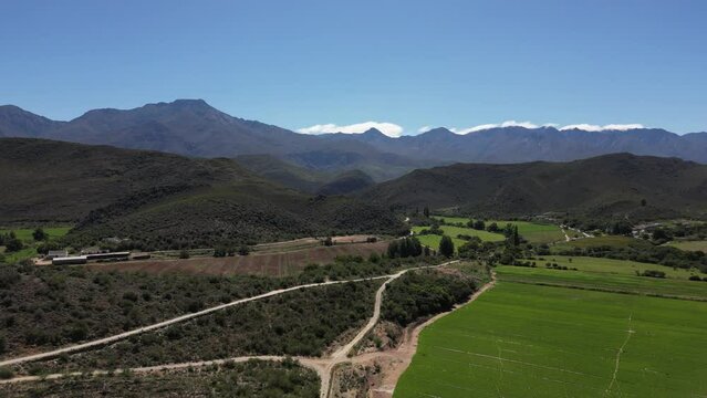 Aerial view - Drone flight over fields and trees - The Swartberg Mountains can be seen in the background, Swartberg Pass, South Africa