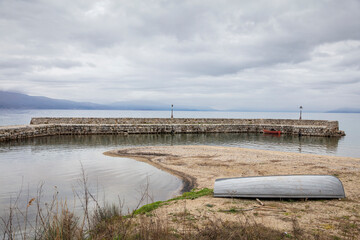 Ohrid, Republic of North Macedonia. Boats at the pier of the Black Drim's Springs near Ohrid Lake in Naum , Macedonia. Beautiful landscape with green forest and mountain.