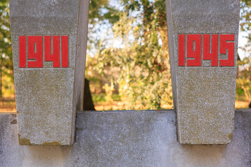 Two cement pillars with red letters on them, one of which reads 1941 1945