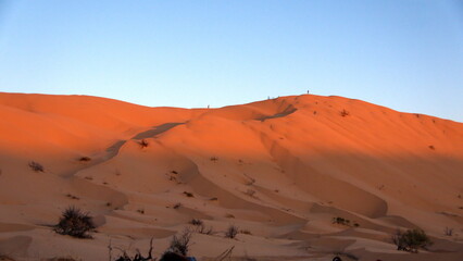 Fototapeta na wymiar Sunrise casting a shadow over the Sahara Desert, outside of Douz, Tunisia