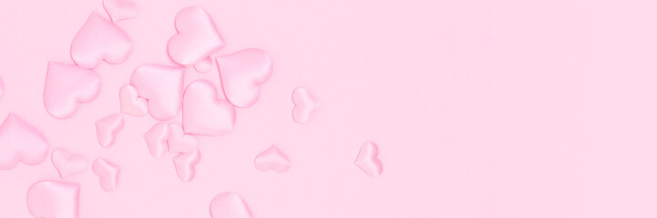 Banner with textile hearts confetti on a pink background. Place for text.