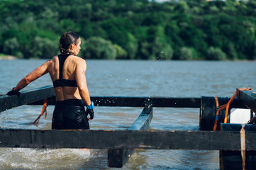 Rear view of a female participating in an obstacle course race outdoor