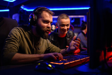 ESports bearded male gamer playing online strategy video game on a computer
