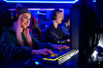 Female esport gamer with a cap and a pink hair playing online video games