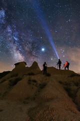Group of astrophotographers photograph the night sky and the Milky Way over the Monegros desert,...