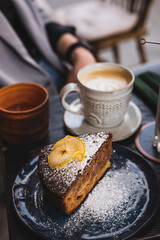A piece of homemade cake and coffee. Breakfast in a cafe on the street.