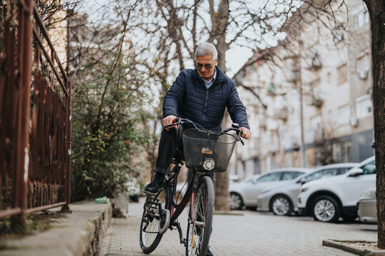 An active senior male rides his bicycle with confidence along a peaceful suburban road, showcasing healthy lifestyle choices in elder years.