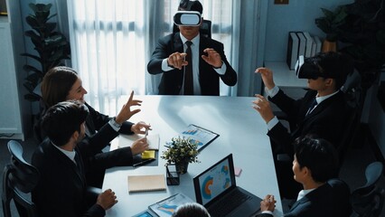 Top view of manager working on laptop and sending data analysis to business people by using VR glass headset while diverse team planning marketing strategy and looking at financial graph. Directorate.