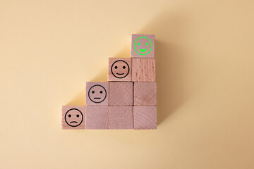 Close up top view customer hand choose smiley face on wood cube, Service rating, satisfaction...