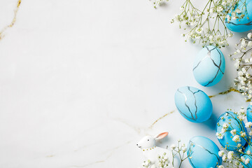 White background with blue eggs and white flowers. Happy Easter greeting card.