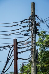 A power pole with many wires and cables hanging from it
