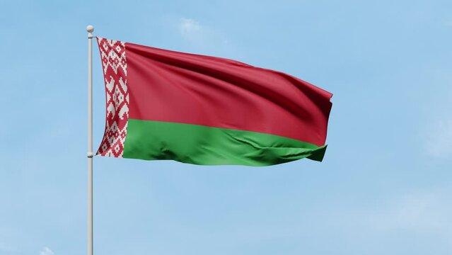 Flag of Belarus with two horizontal stripes of green and red color and traditional pattern flutters in the wind against a blue sunny sky