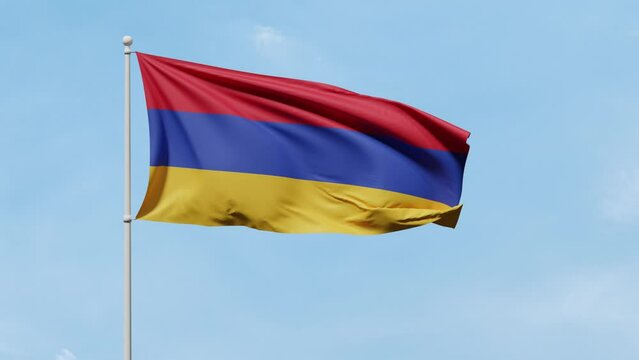 Flag of Armenia with three horizontal stripes of red, dark blue, and mustard yellow color flutters in the wind against a blue sunny sky