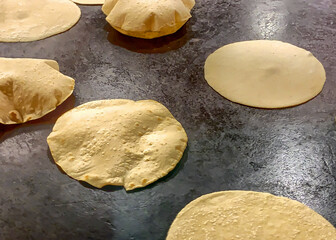 Flour tortillas rising on a hot griddle
