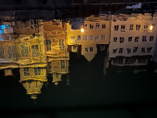 Reflection of Gdańsk, Poland houses in a canal at night creating abstract art