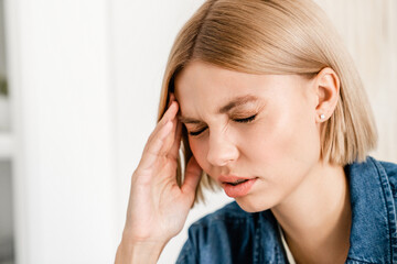 Caucasian young woman rubbing temples suffering from headache. Closeup cropped photo of female...