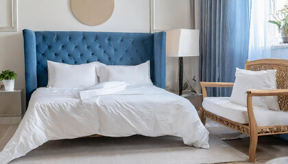 interior with white bed linen on the sofa bedroom with bed white bedding and bedside table white pillows duvet and duvet case on bed with blue headboard front view