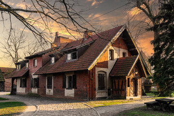 Street in the Baltic village. Old brick abandoned house in the traditional style	
