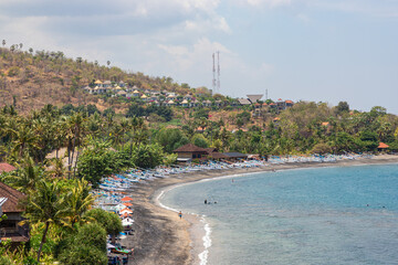 Amed beach with many snorkeling tourists in water. Bali, Indonesia