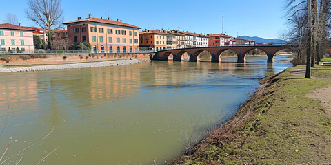 Fototapeta premium A bridge spans over a body of water, with buildings visible in the background