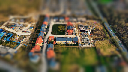 Tilt-shift aerial view of a residential neighborhood, giving a miniature effect to the houses and...