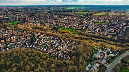Aerial view of a suburban area with houses and green spaces, showcasing a mix of residential living...
